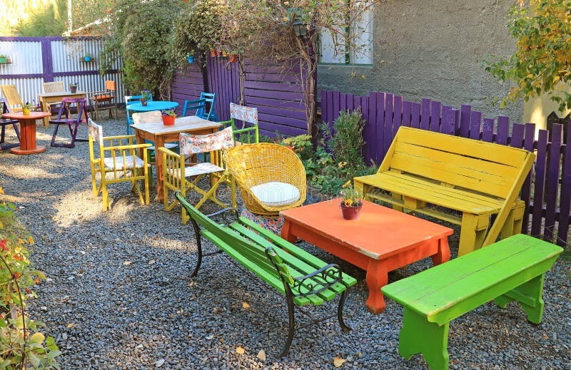 Colorful Empty Chairs And Table In The Backyard Garden Stock Photo