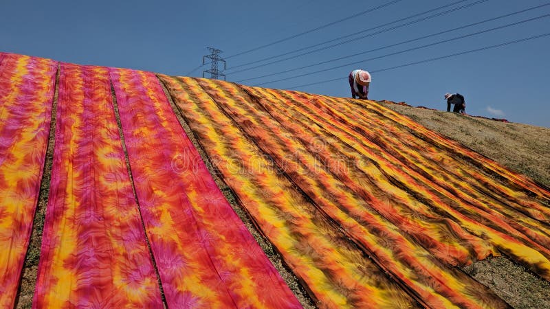 Colorful fabric drying after traditional dye process stock photography