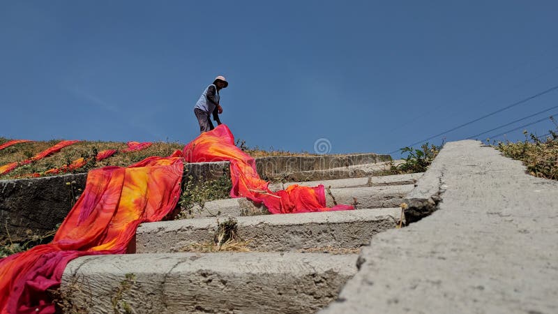 Colorful fabric drying after traditional dye process royalty free stock images
