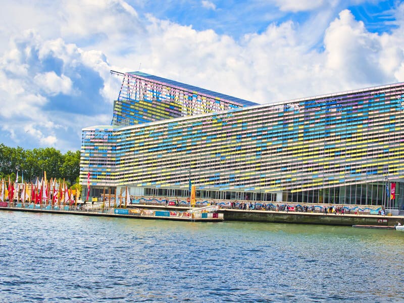 Colorful facade of a building with a vibrant rectangular window pattern. Glasses change color with sun time