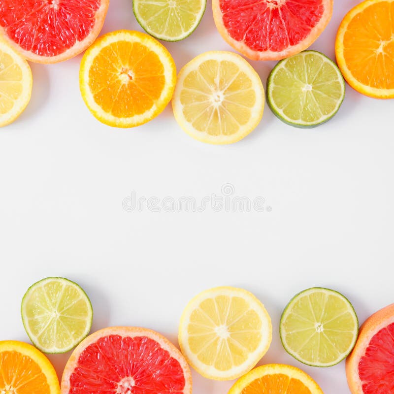 Colorful fruit square double border of citrus slices, top view over a white background royalty free stock images