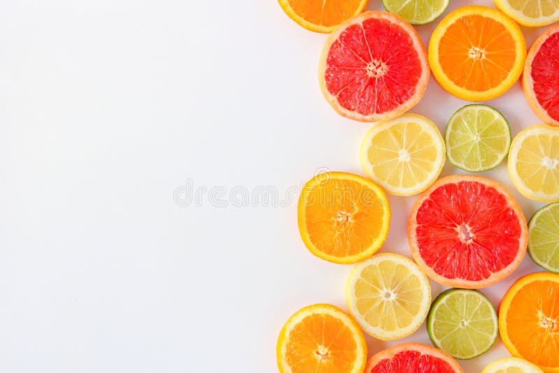 Colorful fruit side border of citrus slices, top view over a white background stock photos