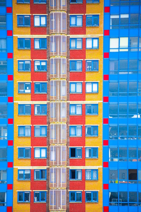Colorful geometric apartment building facade with windows stock images