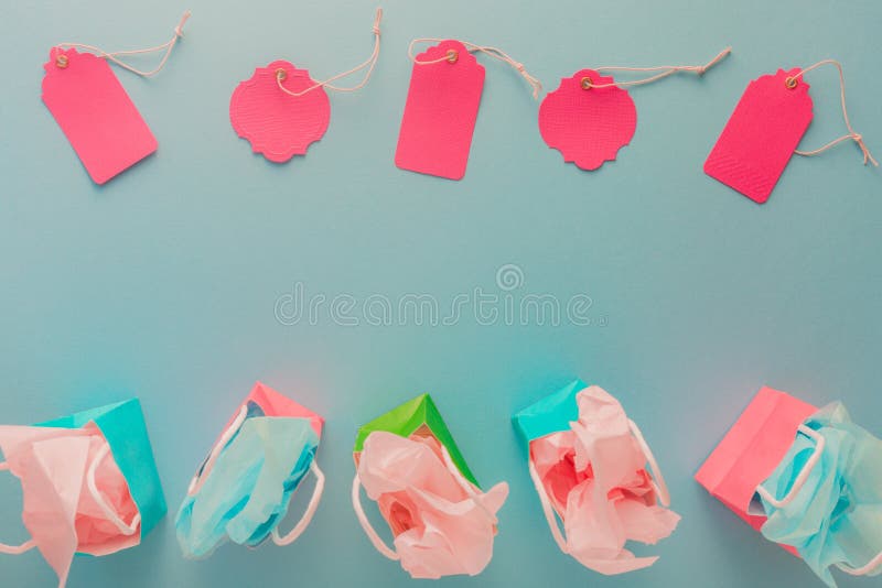 Colorful gift paper bags and pink tags on blue background with c