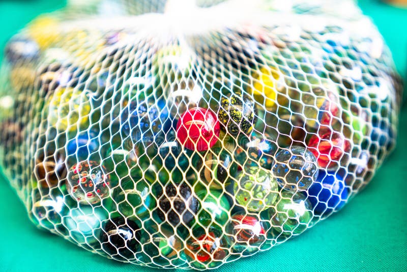 Colorful glass marbles in net stock photos Colorful glass marbles in net stock photos