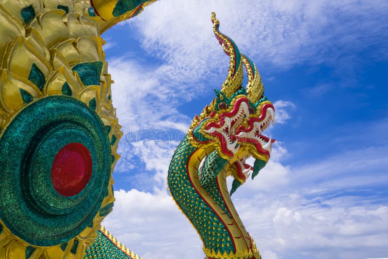 Colorful 3-headed serpent statue against white cloud in blue sky royalty free stock photos