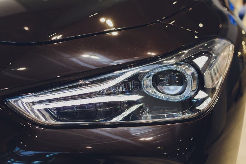 Colorful Headlights of White Car after the Rain at Night on Car Parking