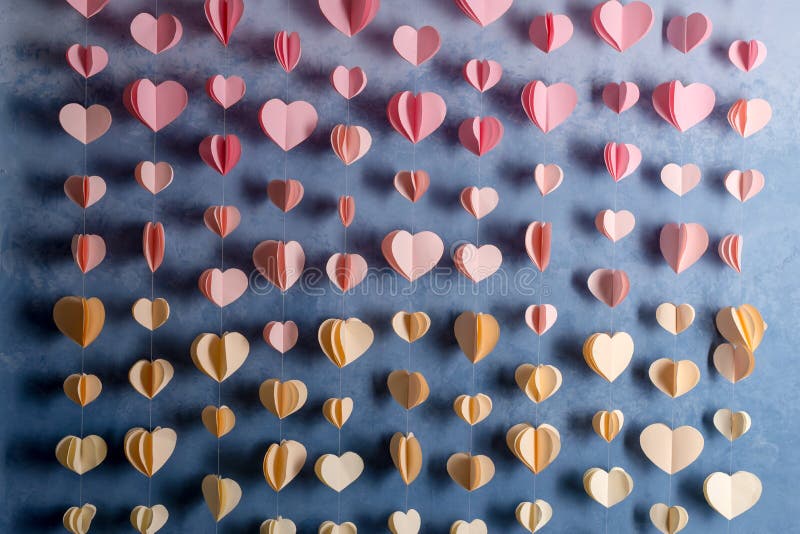 Colorful hearts paper garland hanging on the wall. Romantic Valentine's day background.