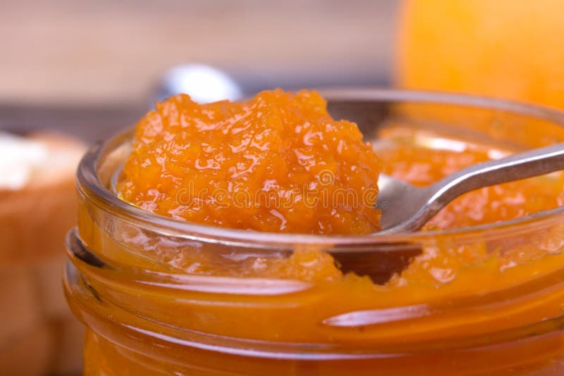 Colorful homemade orange jam in glass jar with