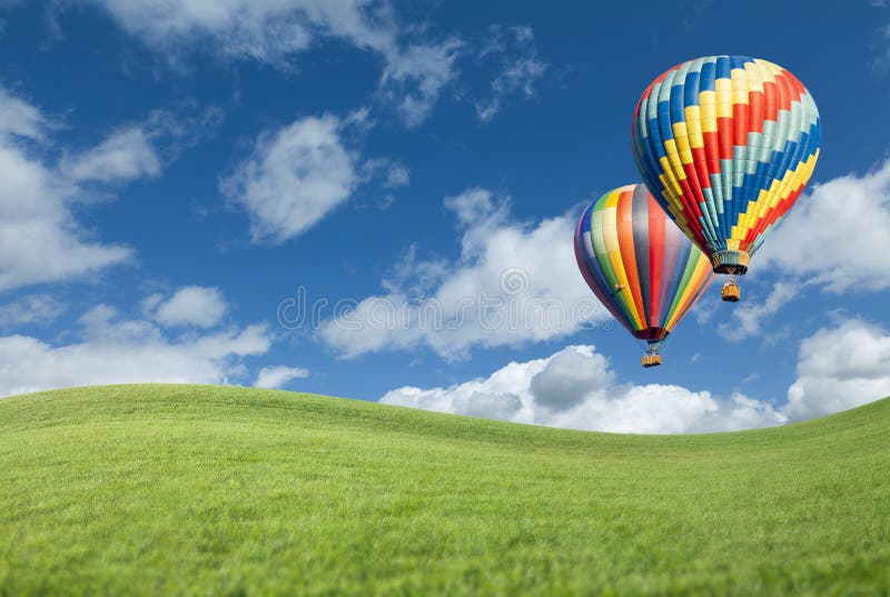 Colorful Hot Air Balloons In Beautiful Blue Sky Above Grass Field