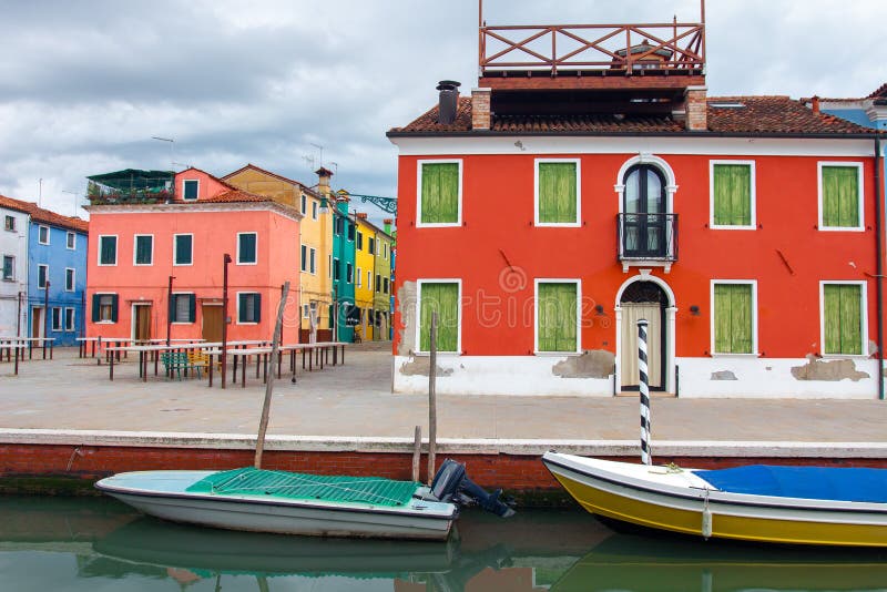 Colorful houses and boats in water canal in Burano island, Venice, Italy. Burano cityscape