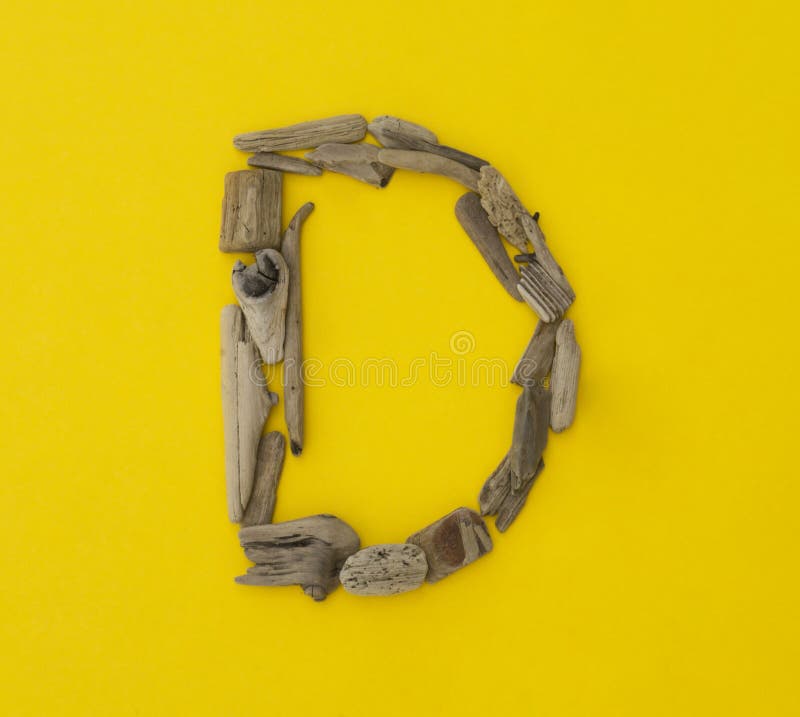 Colorful letter `d` made of wooden sticks on yellow background. stock photos Colorful letter `d` made of wooden sticks on yellow background. stock photos