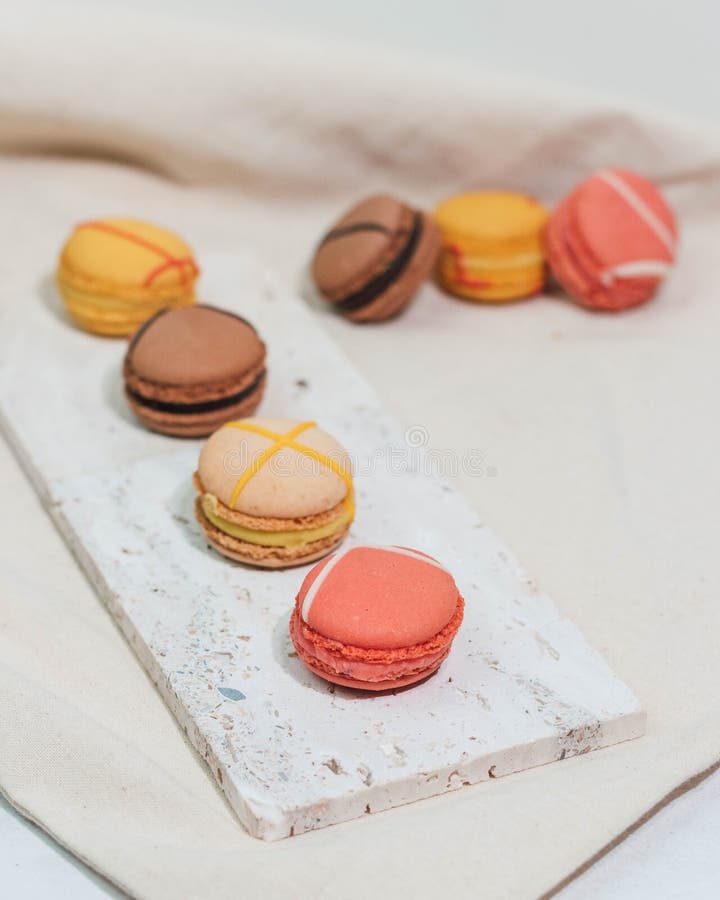 Colorful macarons and delicate roses arranged on a table stock image