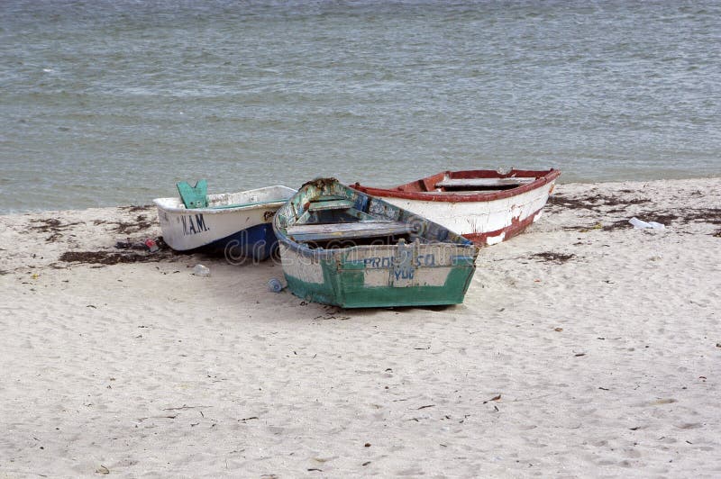 Colorato vecchie barche da pesca parcheggiato su una spiaggia in Progresso, in Messico.