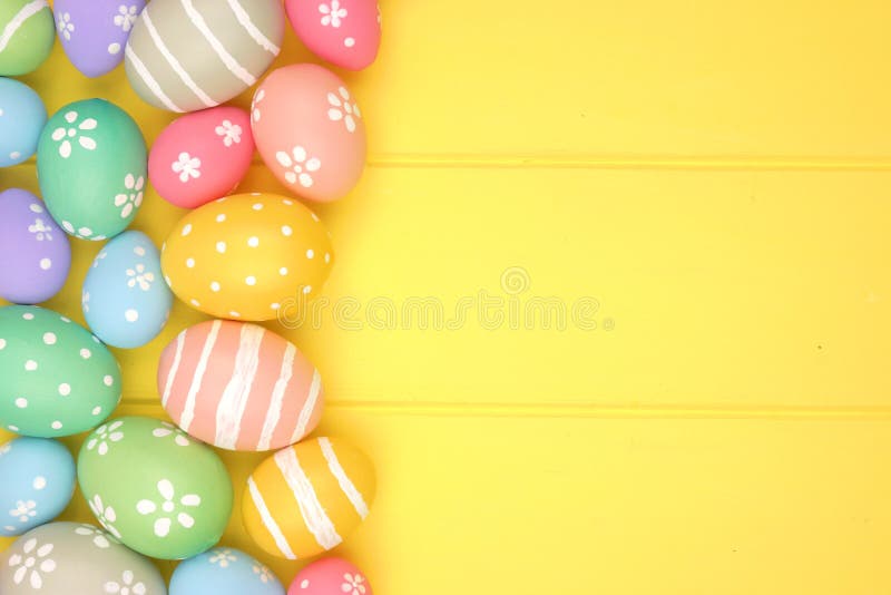 Colorful pastel Easter Egg side border against a yellow wood background royalty free stock photo Colorful pastel Easter Egg side border against a yellow wood background royalty free stock photo
