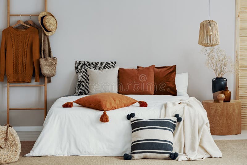 pillows on white bed of classy bedroom with round wooden bedside table and ladder stock photography pillows on white bed of classy bedroom with round wooden bedside table and ladder stock photography