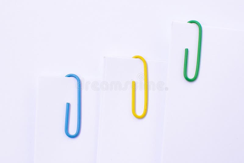 Colorful Plastic Paper Clips Attached To a Blank White Paper. Stock