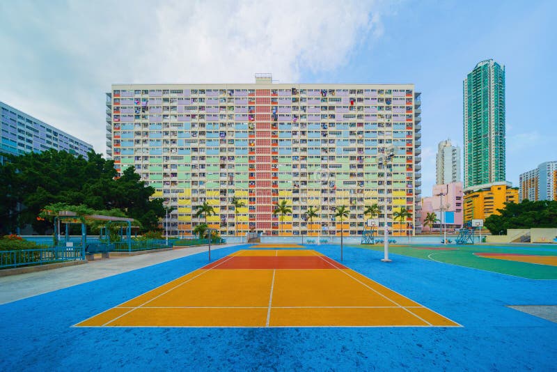 Colorful rainbow pastel building with basketball court and facade windows background in public park. Architecture building design