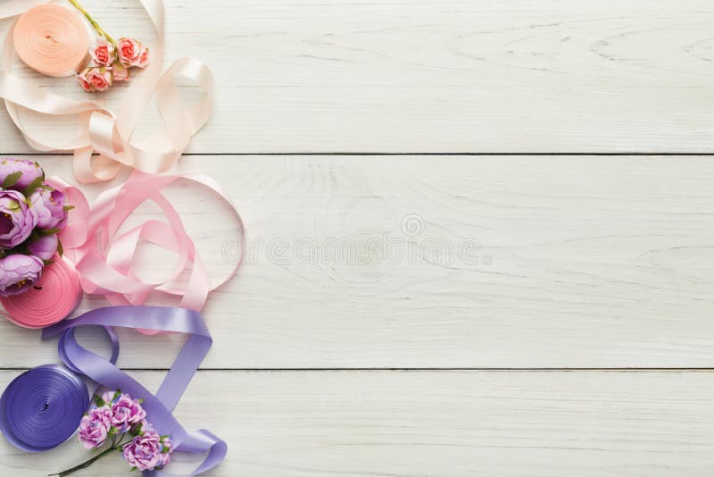 Colorful ribbons and garter on wooden table, wedding preparations background