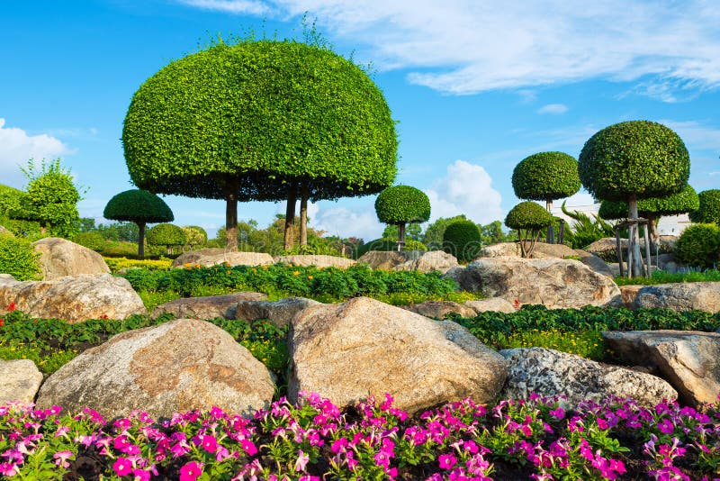 Colorful round cutting shape trees and flowers with rock decoration on cloudy blue sky background stock image Colorful round cutting shape trees and flowers with rock decoration on cloudy blue sky background stock image