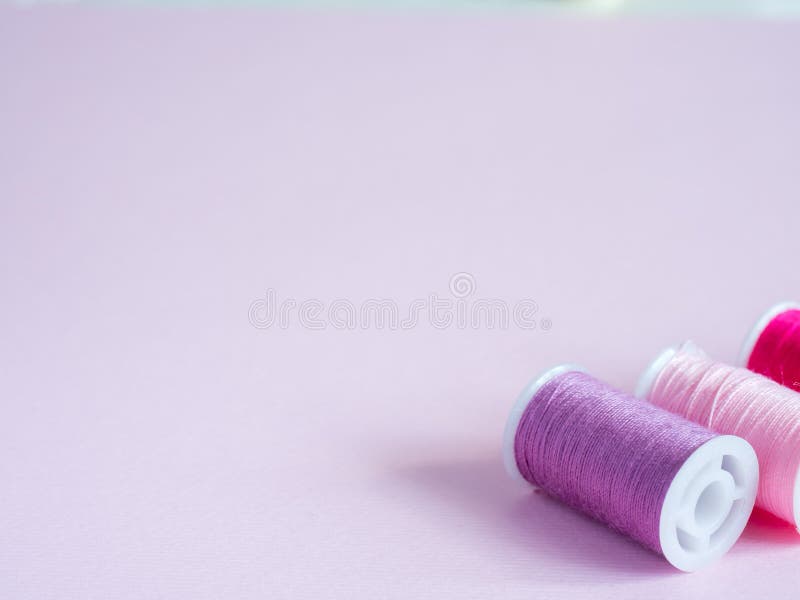 Colorful Sewing Buttons and Thread on a Pink Background. Stock Photo
