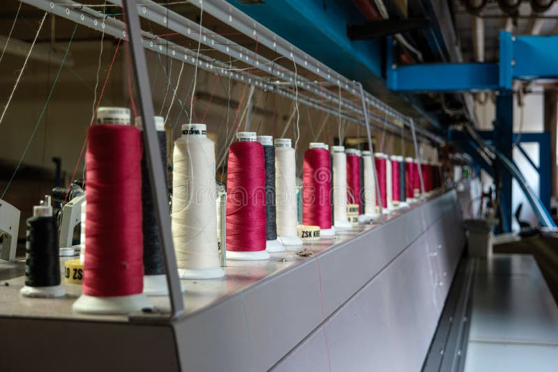 Colorful Sewing Thread Rolls Sitting on Top of Industrial Embroidering Machines Stock Photo