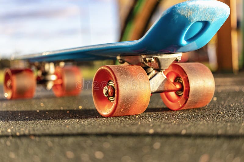 Colorful Skate Board with Orange Wheels Closeup on the Playground