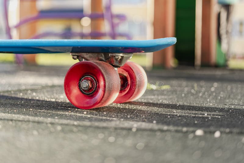 Colorful Skate Board with Orange Wheels Closeup on the Playground