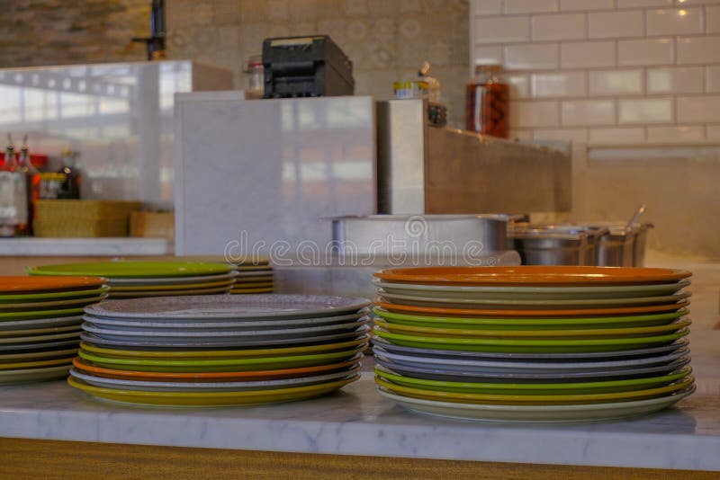 Colorful Stack of Plates in the Kitchen. Kitchen Utensils on the Table