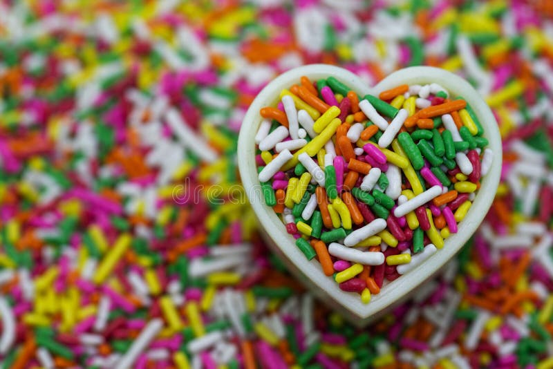 Colorful sugar sprinkles on a heart-shaped cake mold