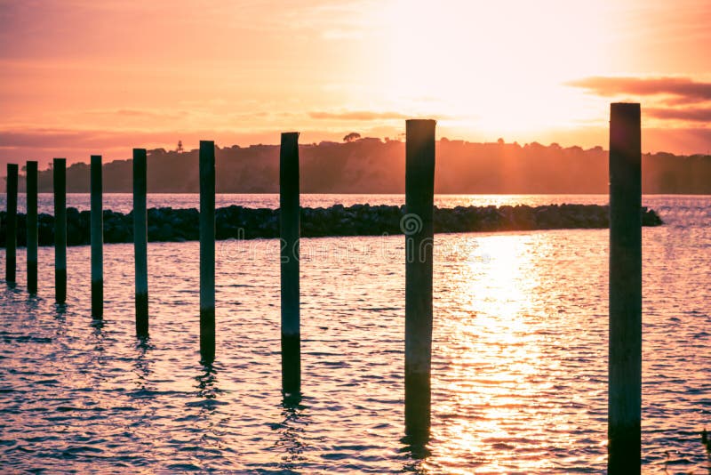 Colorful sunset over Gulf Harbour marine. Mooring poles lined up towards horizon royalty free stock photos Colorful sunset over Gulf Harbour marine. Mooring poles lined up towards horizon royalty free stock photos