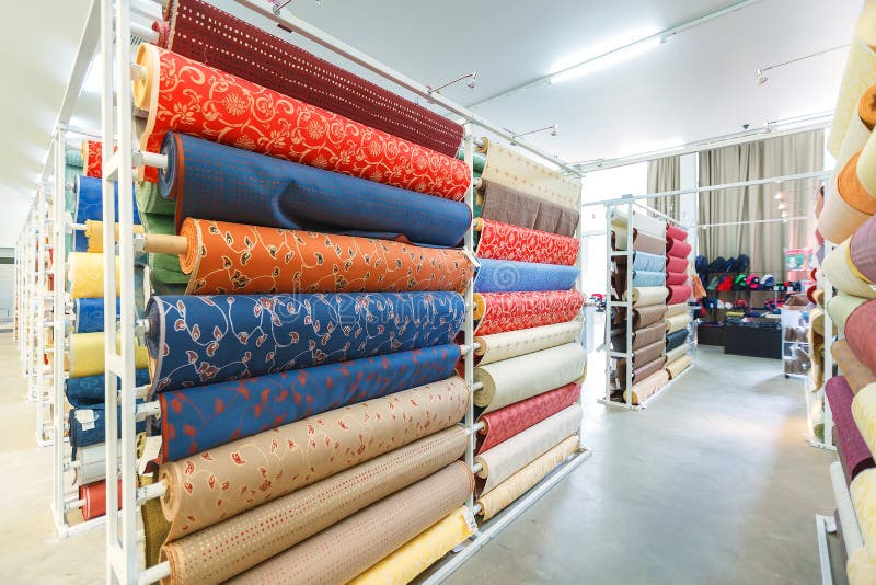 Colorful textile fabric material rolls in warehouse