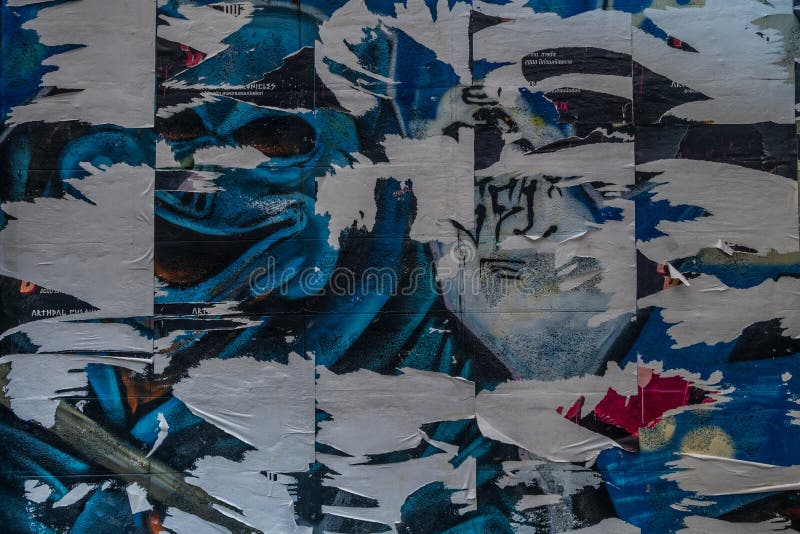 Colorful torn posters on grunge old walls as creative and abstract background