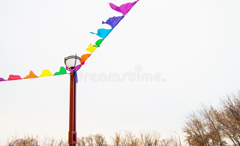 Colorful triangular cloth flags hanging on ropes tied to a lamppost, decoration for festival, carnival, holiday stock photo Colorful triangular cloth flags hanging on ropes tied to a lamppost, decoration for festival, carnival, holiday stock photo