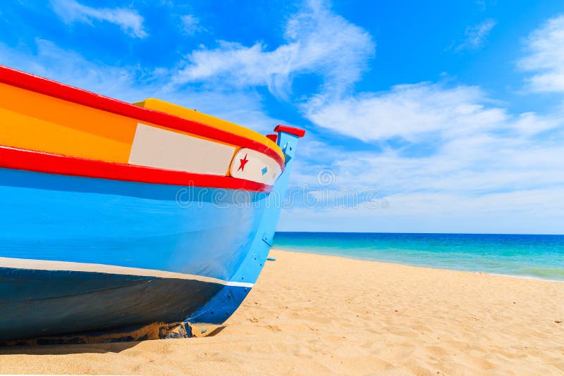 Colorful typical fishing boat on sandy beach