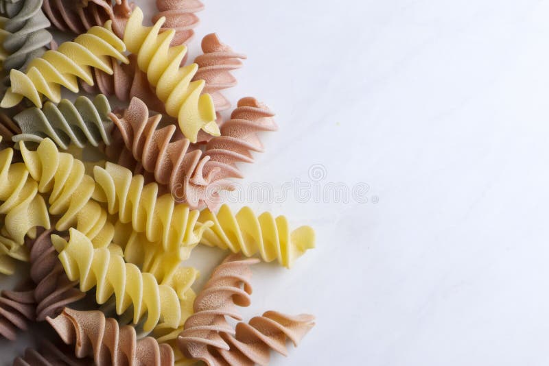 Colorful uncooked pasta on light background