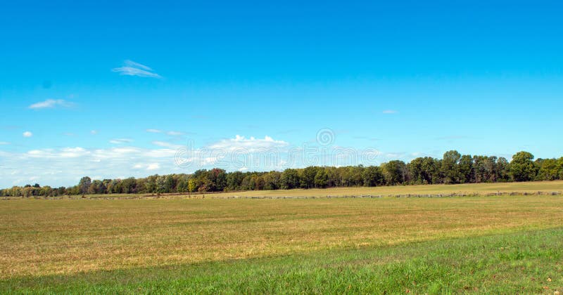 Câmp deschis lat, colorat. Câmp frumos deschis, cu diferite culori verzi și albastre. un gard rustic din lemn care trece prin centru prinde ochiul din peisajul Arkansas. o atmosferă relaxantă de pace și liniște