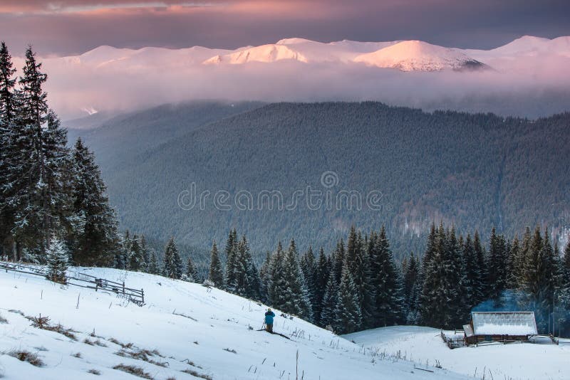 Colorful winter sunrise in the mountains. View of the old farm and tourist near. stock photo Colorful winter sunrise in the mountains. View of the old farm and tourist near. stock photo