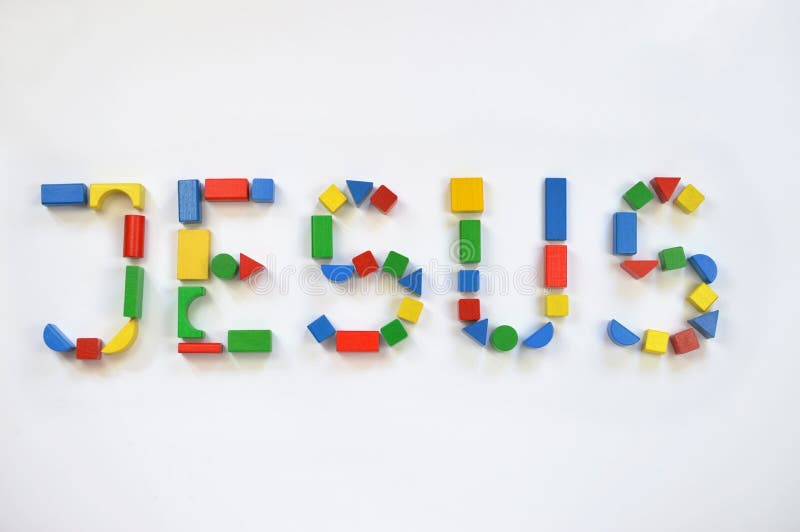 Colorful wooden toy blocks lettering JESUS royalty free stock photo
