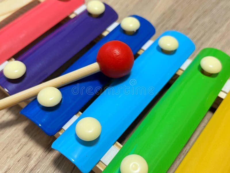 Colorful xylophone being played with a red mallet, showcasing vibrant notes in a rhythmic sequence, highlighting musical creativity and playful interaction with instruments. Colorful musical notes stock images, royalty-free photos and pictures