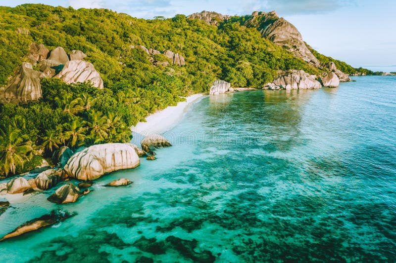 Golden sunset vibe colors at Anse Source D Argent exotic beach at Seychelles. Aerial drone above photo. Golden sunset vibe colors at Anse Source D Argent exotic beach at Seychelles. Aerial drone above photo.