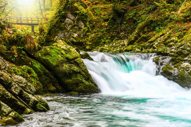 Colori della foresta di autunno con la piccola cascata del turchese in parco naturale di Vintgar immagini stock libere da diritti Colori della foresta di autunno con la piccola cascata del turchese in parco naturale di Vintgar immagini stock libere da diritti