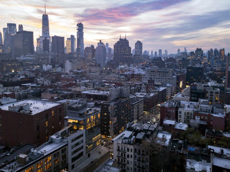 Colorida luz do pôr do sol brilha no céu acima dos edifícios do horizonte inferior de Manhattan, na cidade de Nova Iorque foto de stock Colorida luz do pôr do sol brilha no céu acima dos edifícios do horizonte inferior de Manhattan, na cidade de Nova Iorque foto de stock