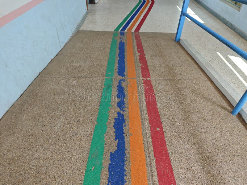 Coloridas líneas en el suelo concreto en un espacio interior luminoso foto de archivo