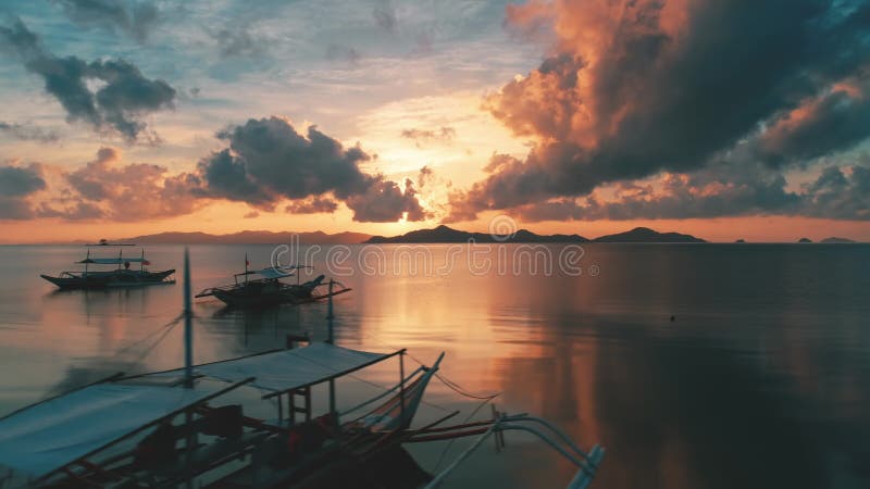 Coloridas nubes brillantes de atardecer cielo sobre el océano tranquilo. avión teledirigido aéreo sobre barcos de pesca almacen de video