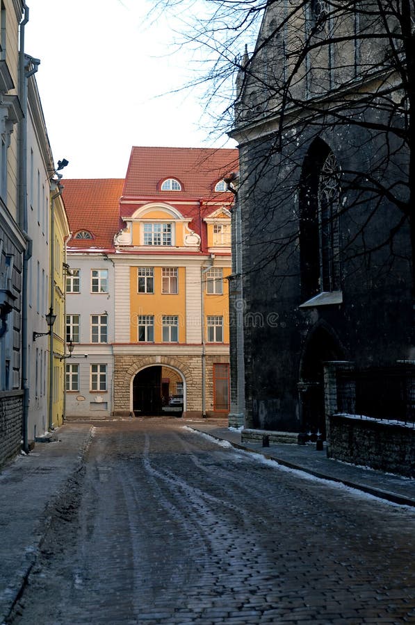 Colorful old buildings in central Tallinn.   Tallinn Old Town has cobbled streets and beautiful architecture. The pretty colors of the houses contrast with the darkness of the church and street. Colorful old buildings in central Tallinn.   Tallinn Old Town has cobbled streets and beautiful architecture. The pretty colors of the houses contrast with the darkness of the church and street.