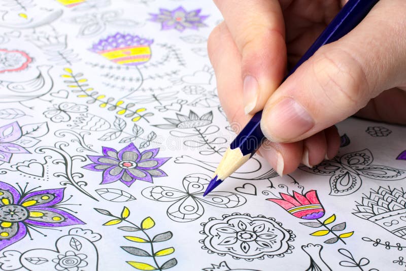 Colorer - antistress with colored pencils.The woman draws thereby relieves stress. Colorer - antistress with colored pencils.The woman draws thereby relieves stress