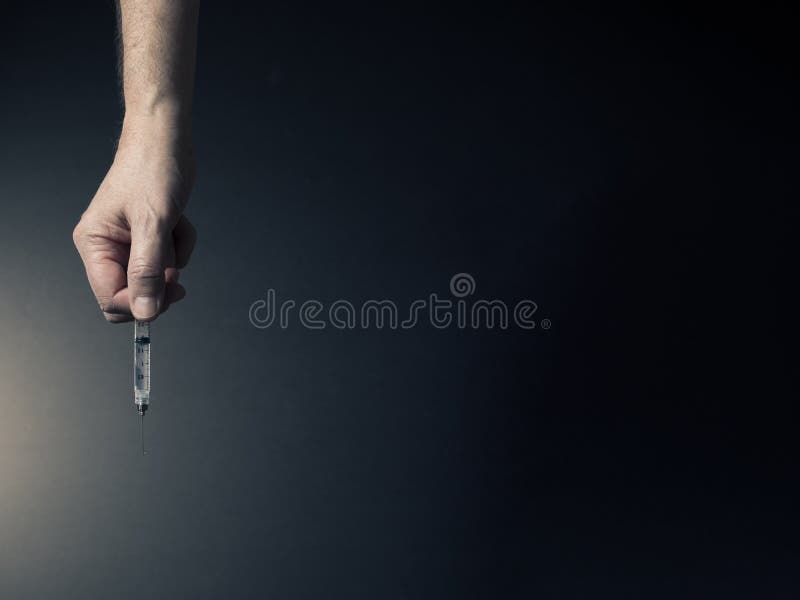 Man`s hand holding syringe stock image