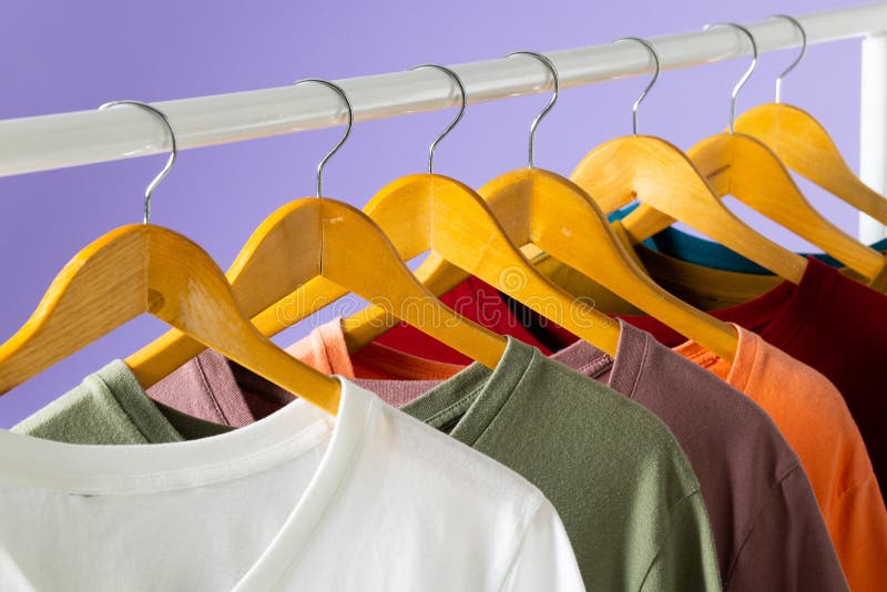Coloured Tshirts Displayed on Clothing Rail and Copy Space on Purple ...