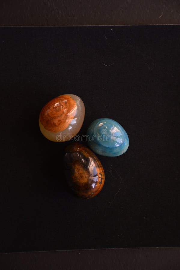 A Colourful Composition of three Gemstones, Brown, Orange, Pink and Turkish Blue on Black royalty free stock image A Colourful Composition of three Gemstones, Brown, Orange, Pink and Turkish Blue on Black royalty free stock image